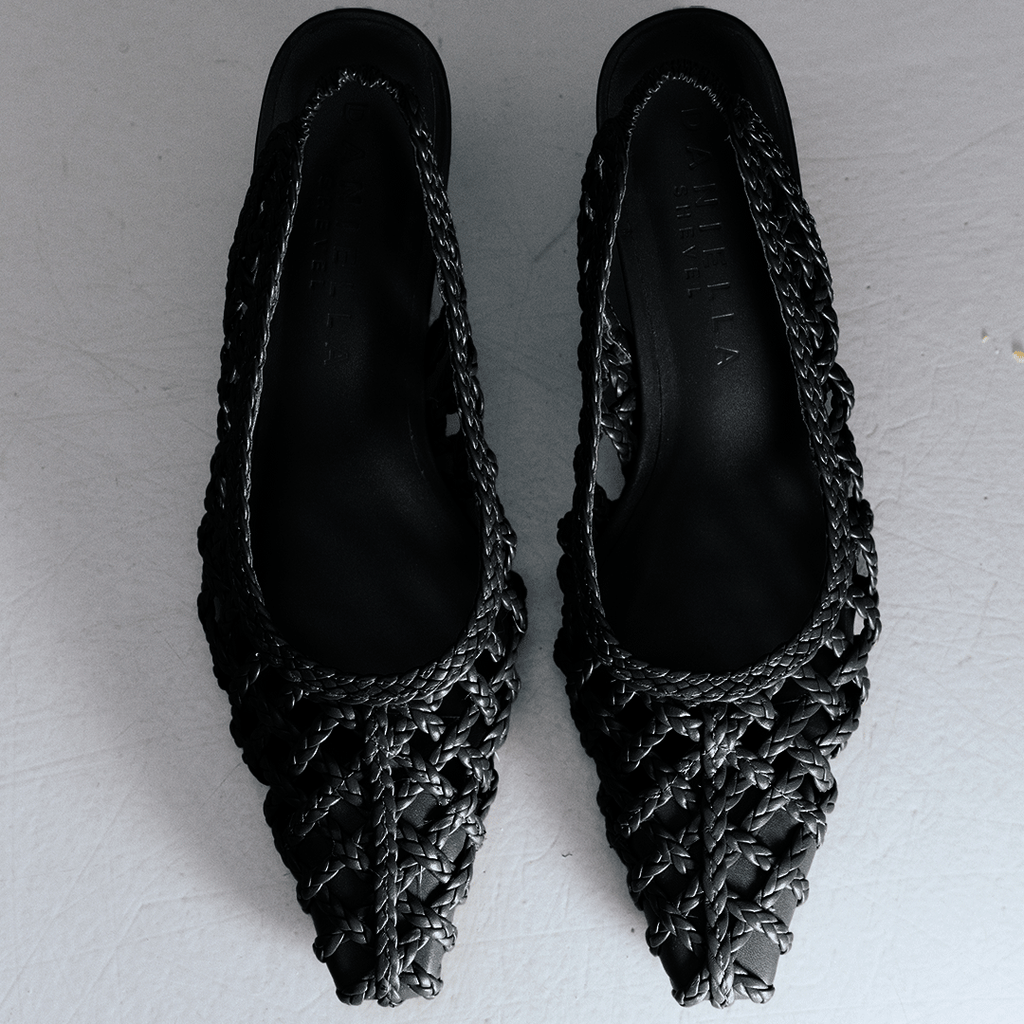 Top-down flat lay of Cora slingback heels in black braided leather, showing intricate woven upper and elegant silhouette.

