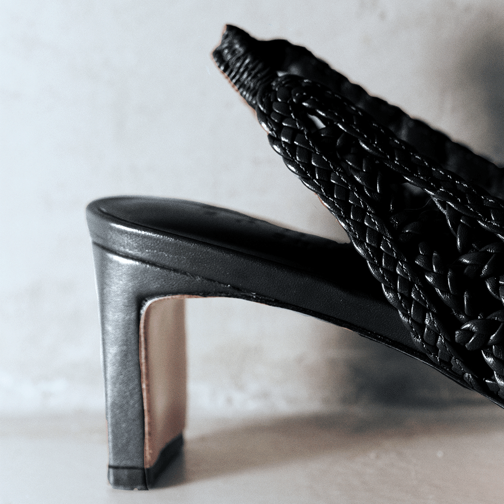 Close-up shot of the heel and braided leather texture of the Cora slingback in black, emphasizing craftsmanship.