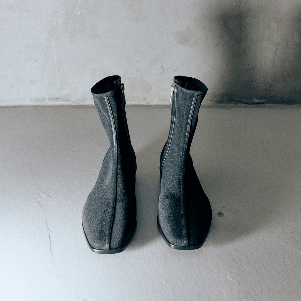 Back view of Daniella Shevel Aliza Black boots in studio, highlighting zipper, seamless design.