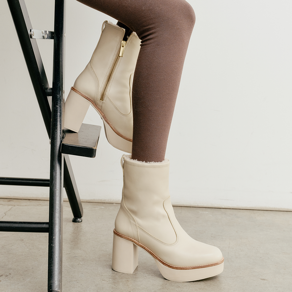 Daniella Shevel Aspen boot in creamy white, Nappa leather with shearling lining, thick rubber sole, leather welt, inside zipper, Shown in side view on a model