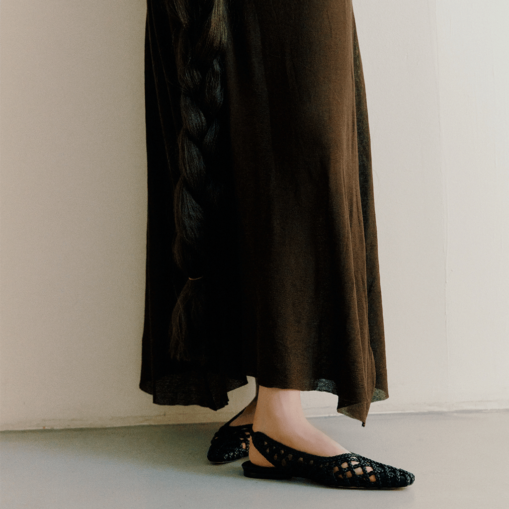 Back view of model walking in Halo Black flats – silhouette accentuates how the shoe hugs the foot.