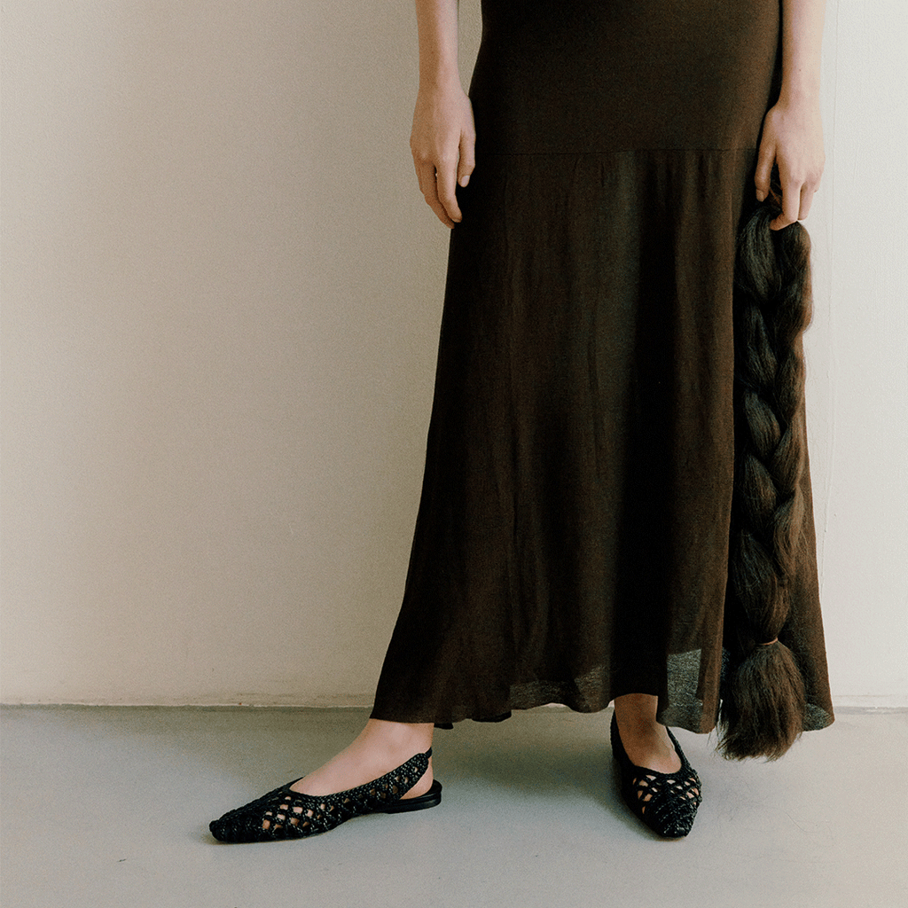 Side step lifestyle shot of model in Halo Black flats – styled with movement, minimalism, and modern femininity.