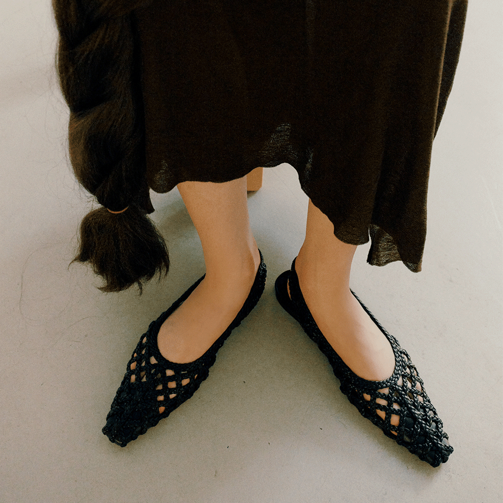 Overhead view of Halo Black flats on model standing still – styled with long knit dress and natural lighting.