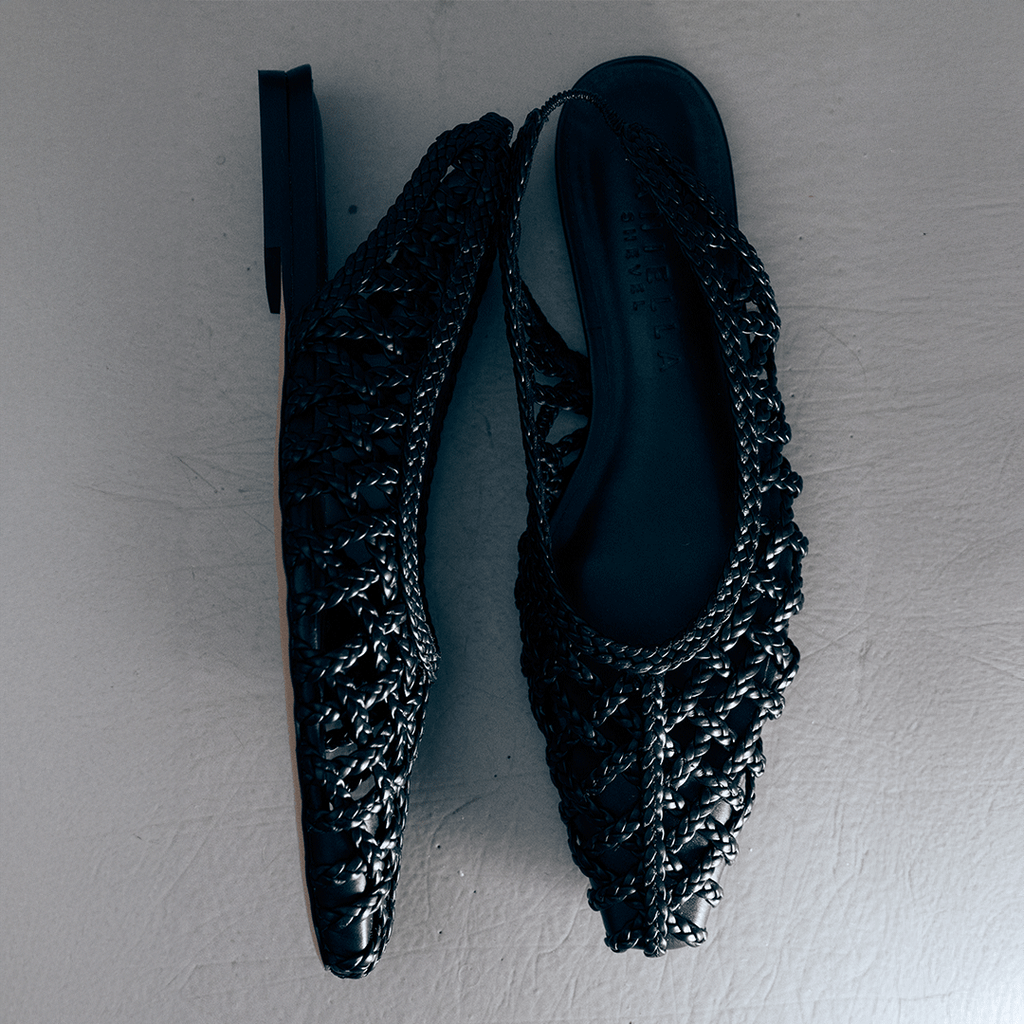 Flat lay of Daniella Shevel Halo flats in Black – pair displayed on neutral floor, revealing the shape and weave in detail.