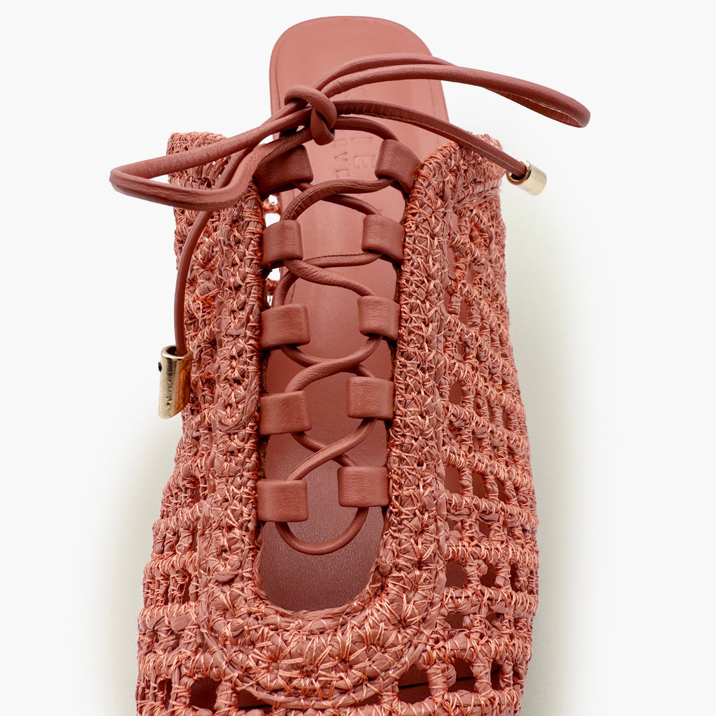 Close-up studio detail of the Daniella Shevel Bruna mule in Berry Petal, featuring luxe leather lacing, woven raffia upper, and curved inset panel for a refined, textural finish.