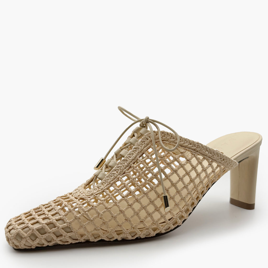 Side angle studio image of Daniella Shevel Bruna Mule – Wild Straw colorway with woven leather design and tapered mid heel.