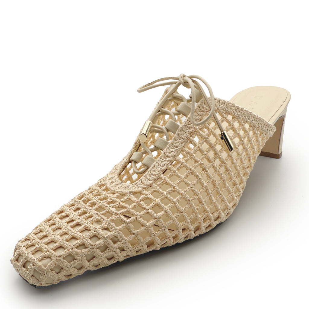 Studio shot of Daniella Shevel Lina Heel Mule in Wild Straw – angled front view showing woven raffia texture, lace-up detail, and almond-shaped toe.