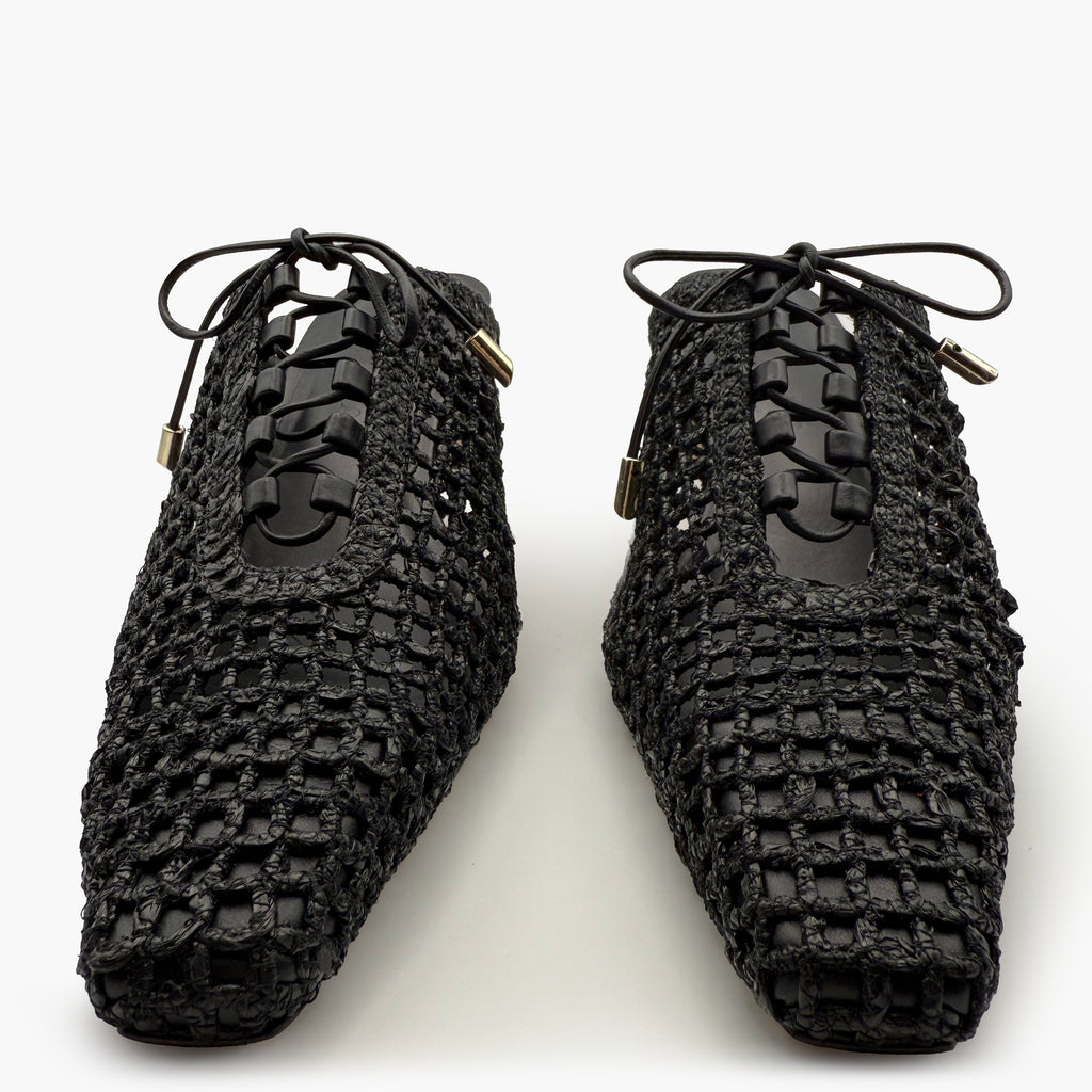 Close-up studio shot of Daniella Shevel black raffia heel mules – detailed view of lace-up front and intricate handwoven texture.