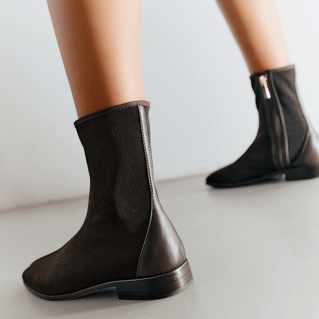 Back angle of Aliza Brown flat boots on model, showcasing seamless heel and elegant shape.