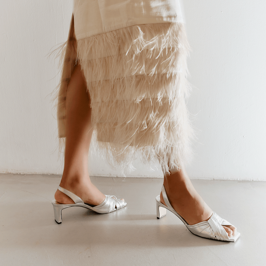 Walking studio look with Riley silver sandals styled with textured skirt.