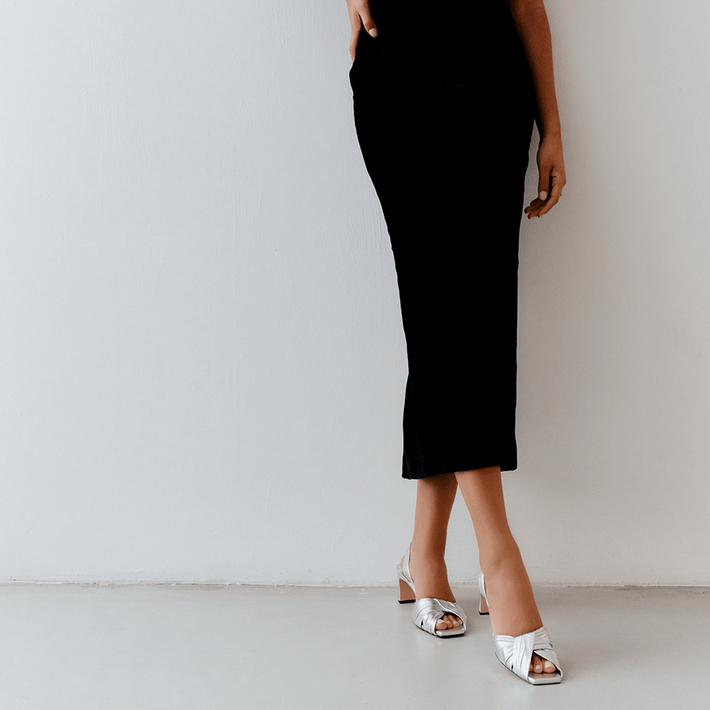 Riley silver sandals styled with black long dress for modern elegance.