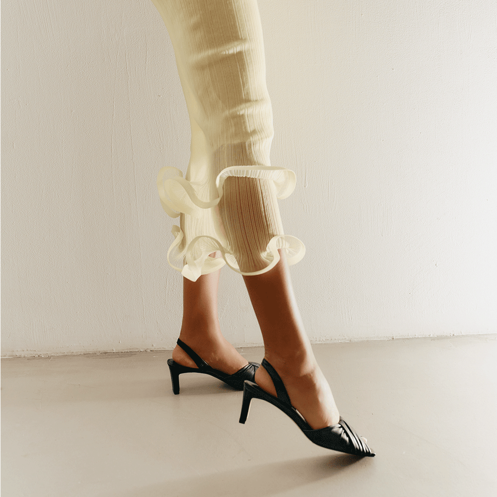 Studio capture of Riley Leather Low-Heel in black, styled with rolled trousers.