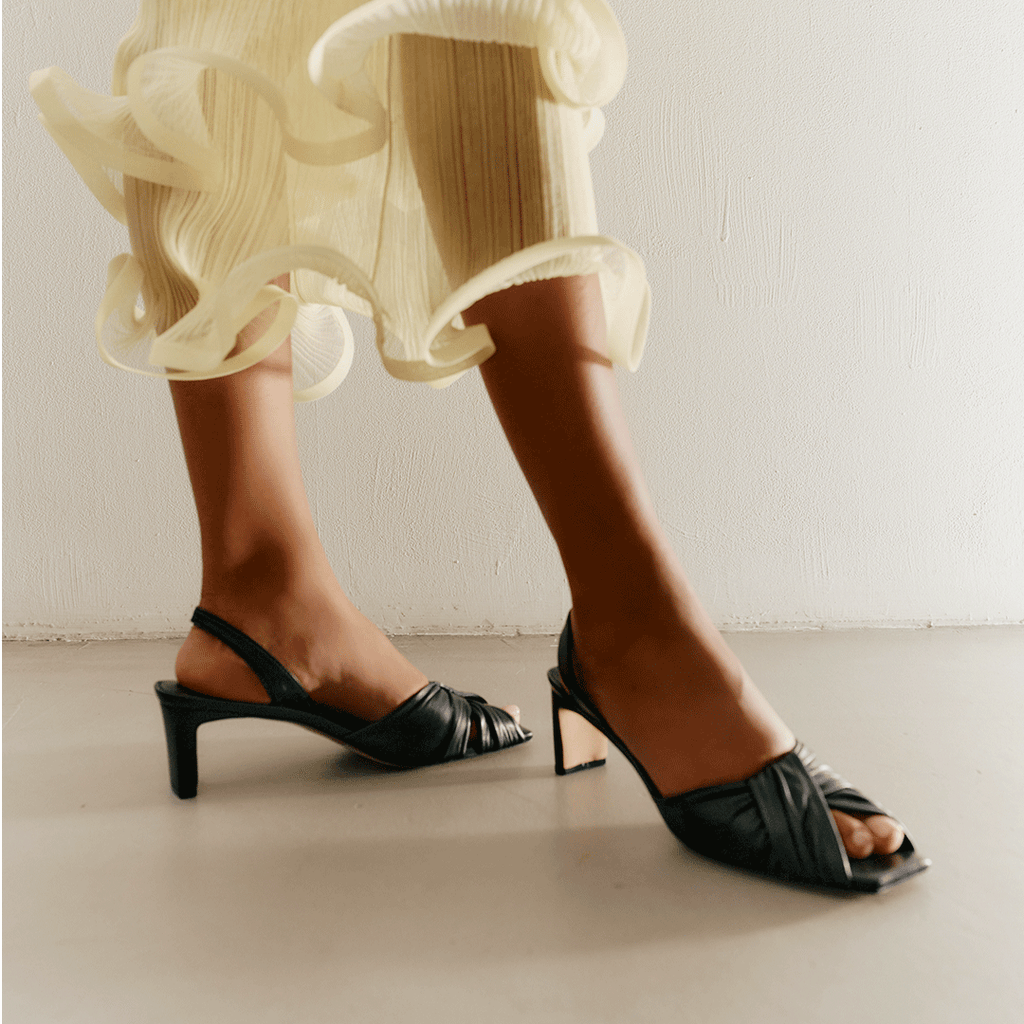 Angled back view of Riley black sandals showing slingback strap.