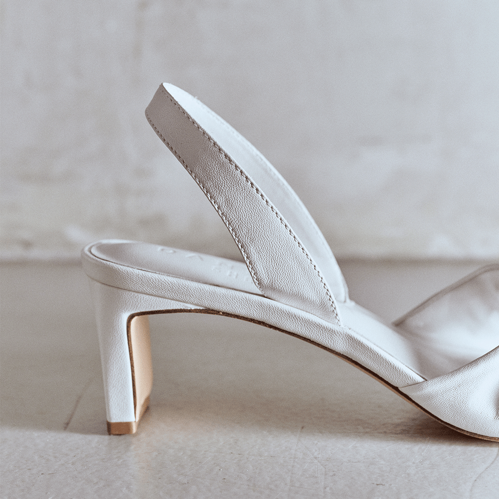 Detailed heel close-up of Riley white sandal with block heel.