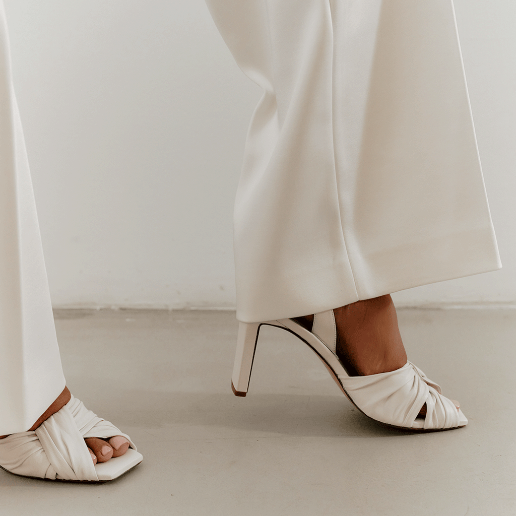 Close-up detail of Skyler slingbacks in white leather, studio shot.