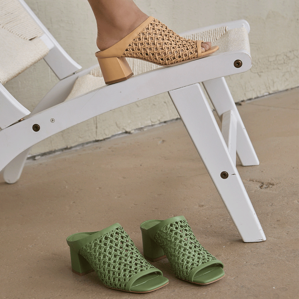 Close-up of Daniella Shevel Sienna Slide sandals in camel, and green, stacked together for a striking color contrast.