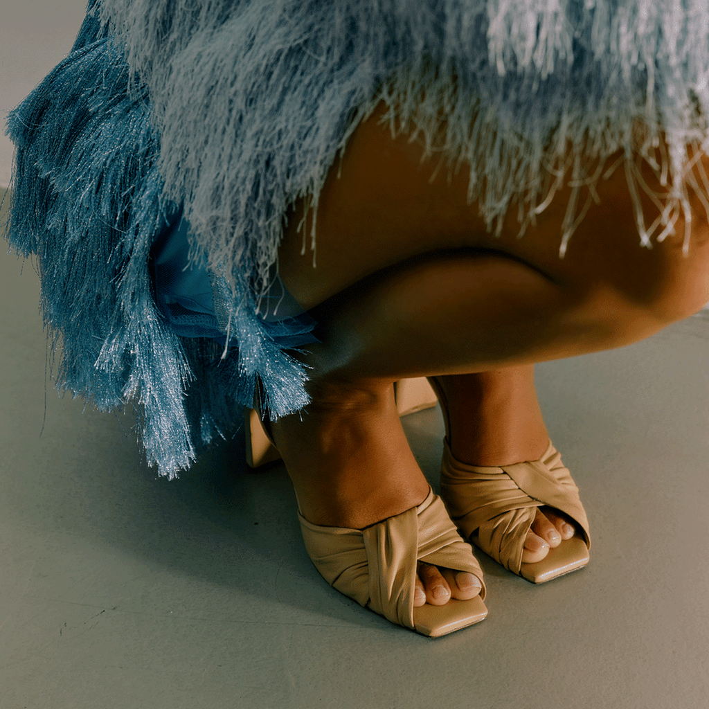 Skyler soft oat leather heels paired with blue textured skirt, lifestyle shot.