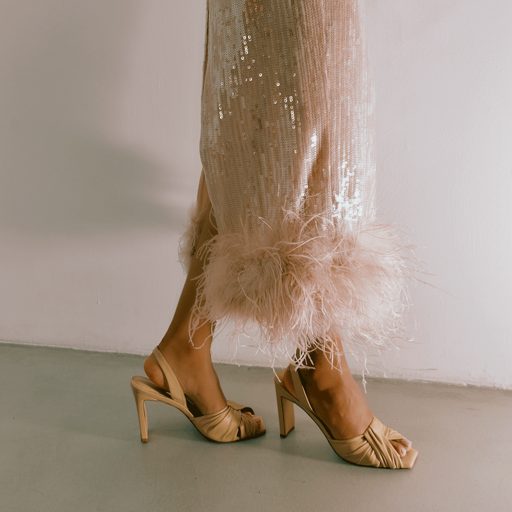 Soft oat Skyler heels paired with sheer skirt, lifestyle styling.