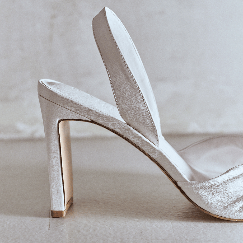 Side angled studio shot of Skyler slingbacks in white leather.