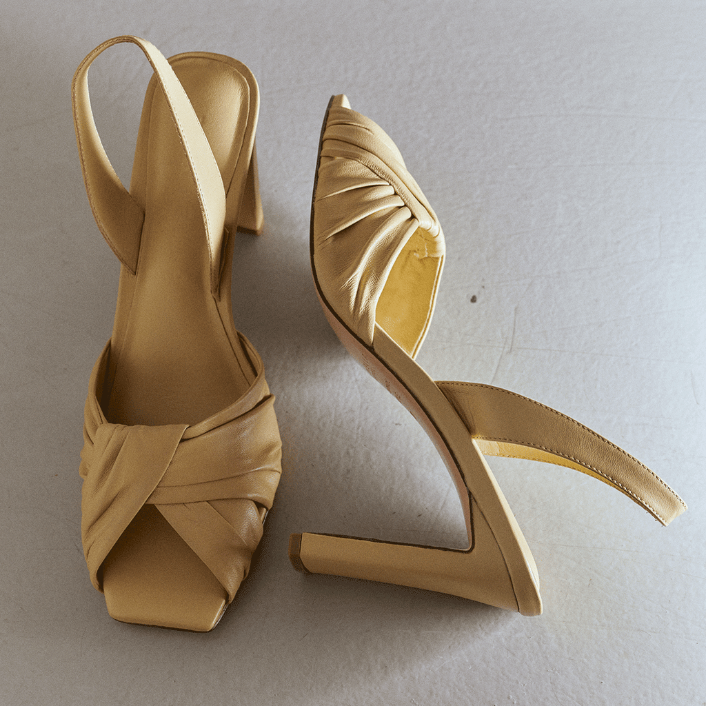 Studio side angle of soft oat Skyler slingback with pointed toe detail.