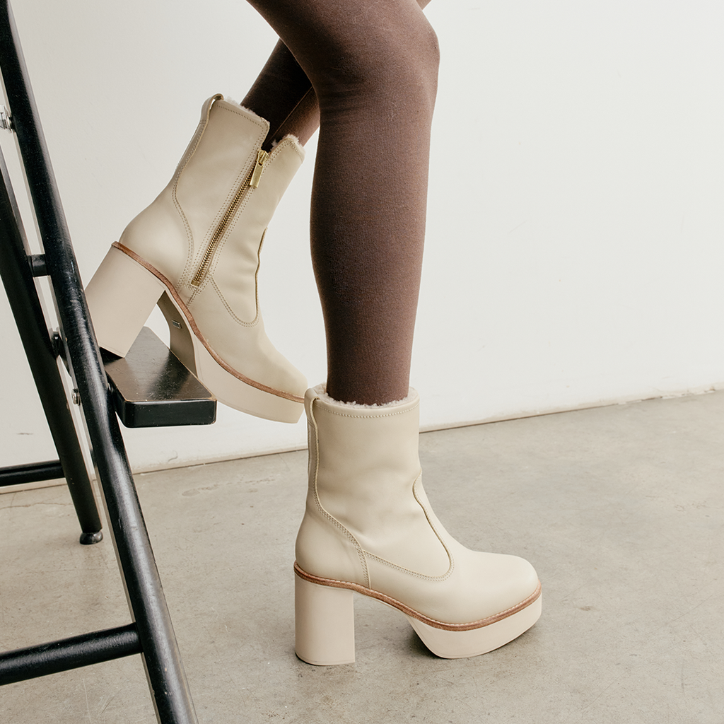 Daniella Shevel Aspen boots in White waterproof and snow proof, shearling lining, thick rubber sole, and inside zipper, in side view on a model shown in close up