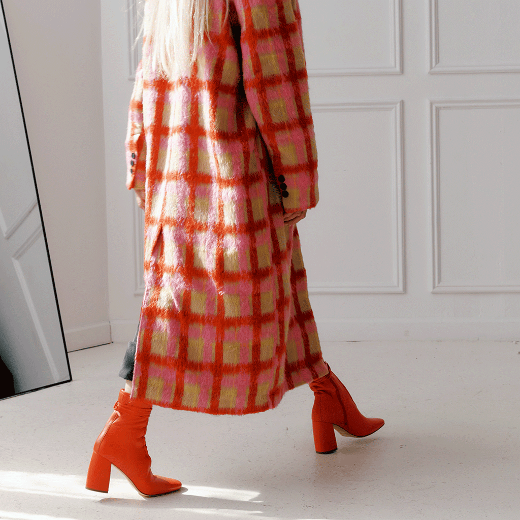 Daniella Shevel Belladonna Lace up boot in lobster red side walking view with winter coat