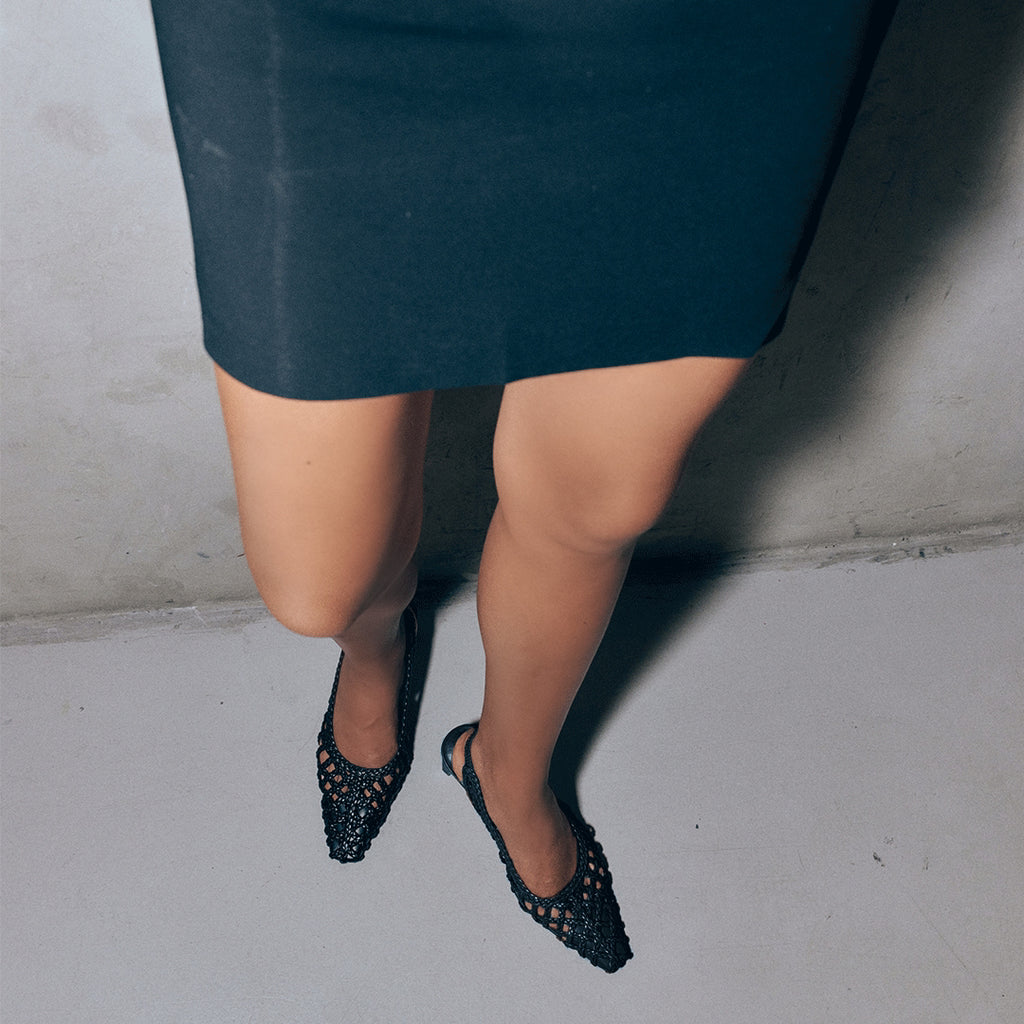 Cora braided leather slingback heels in black styled with a chic outfit, ideal for formal or evening wear.

