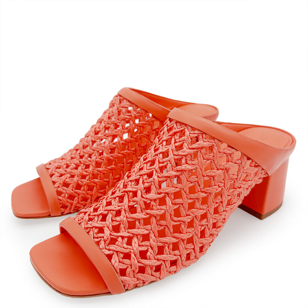 Side-angle shot of Daniella Shevel Sienna Slide sandal in coral, highlighting the block heel and intricate woven leather design.