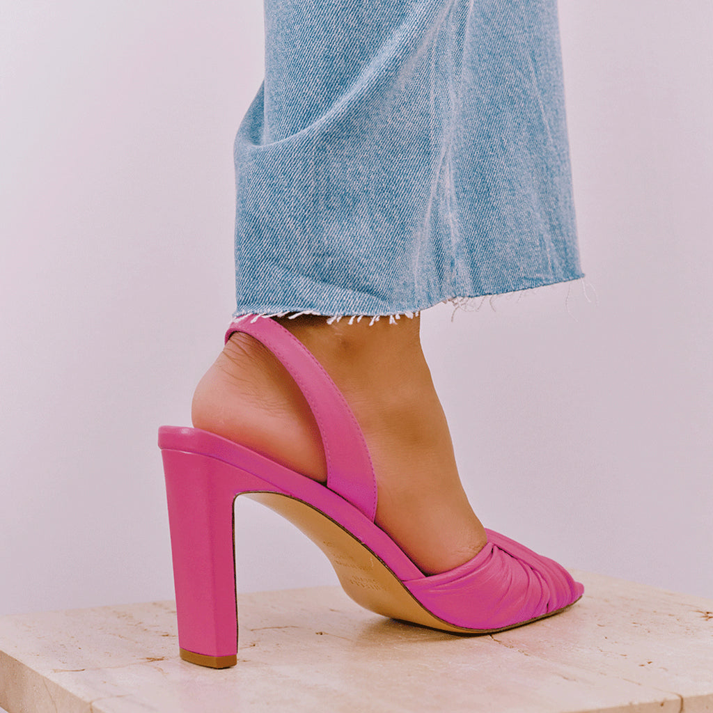 Intense pink Skyler slingbacks paired with cropped pants, studio setting.