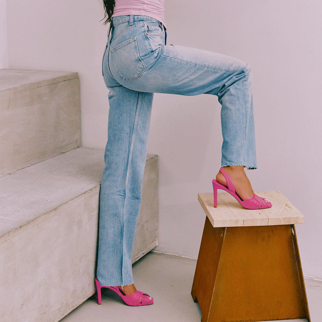 Lifestyle image of Skyler intense pink slingbacks with high waisted denim jeans.
