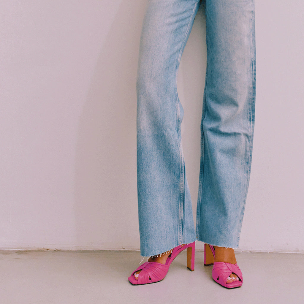Lifestyle styling of Skyler intense pink heels with denim jeans.