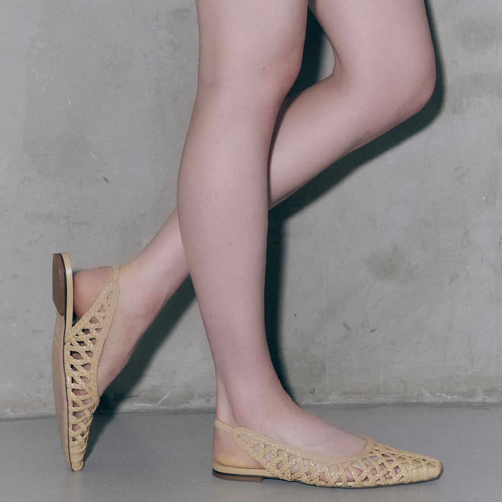 Side profile of model wearing Daniella Shevel Halo flats in Soft Oat – showing off the pointed toe silhouette and low heel.