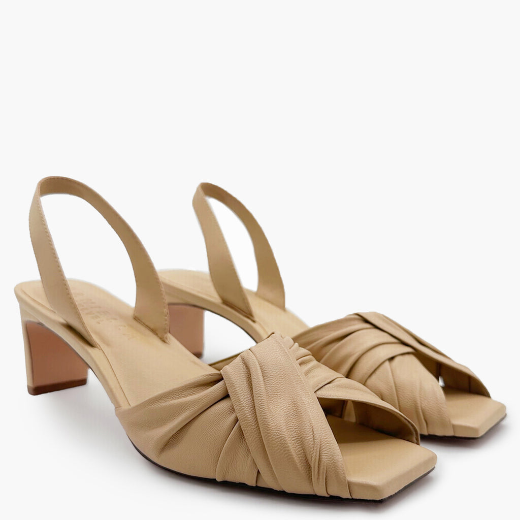 Pair shot of Riley soft oat sandals styled with neutral minimalist scene.