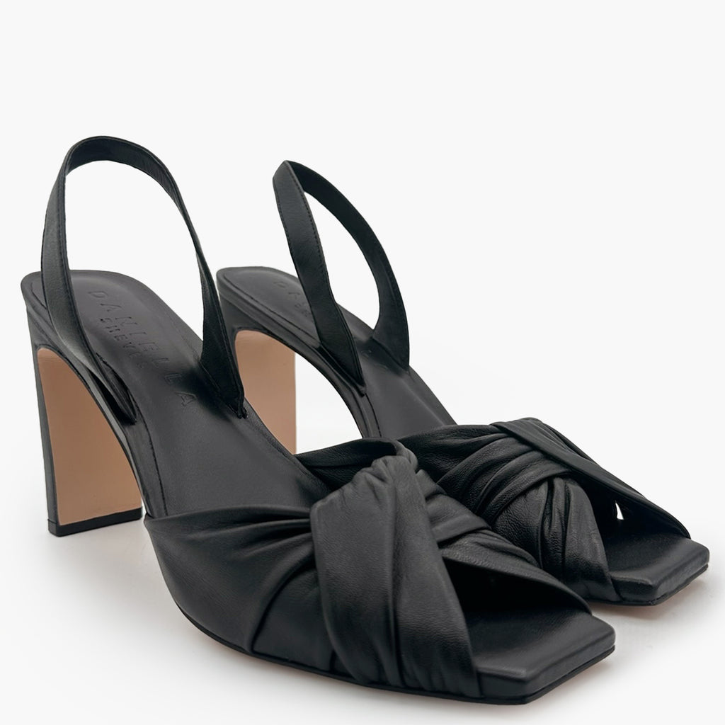 A pair of Daniella Shevel Skyler  high-heel black slingbacks in studio shot, side angled view.
