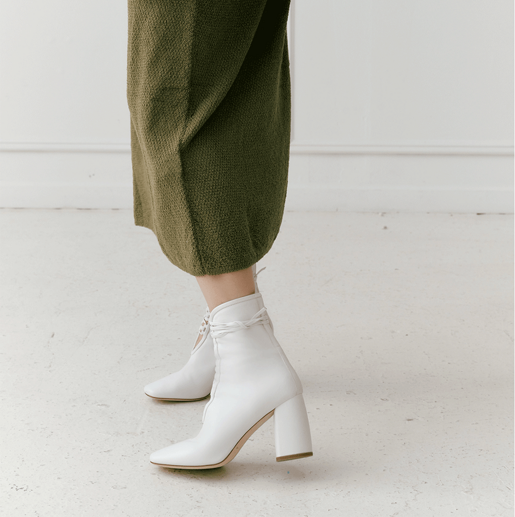 Daniella Shevel Belladonna Lace up boot in white Side view in green midi dress