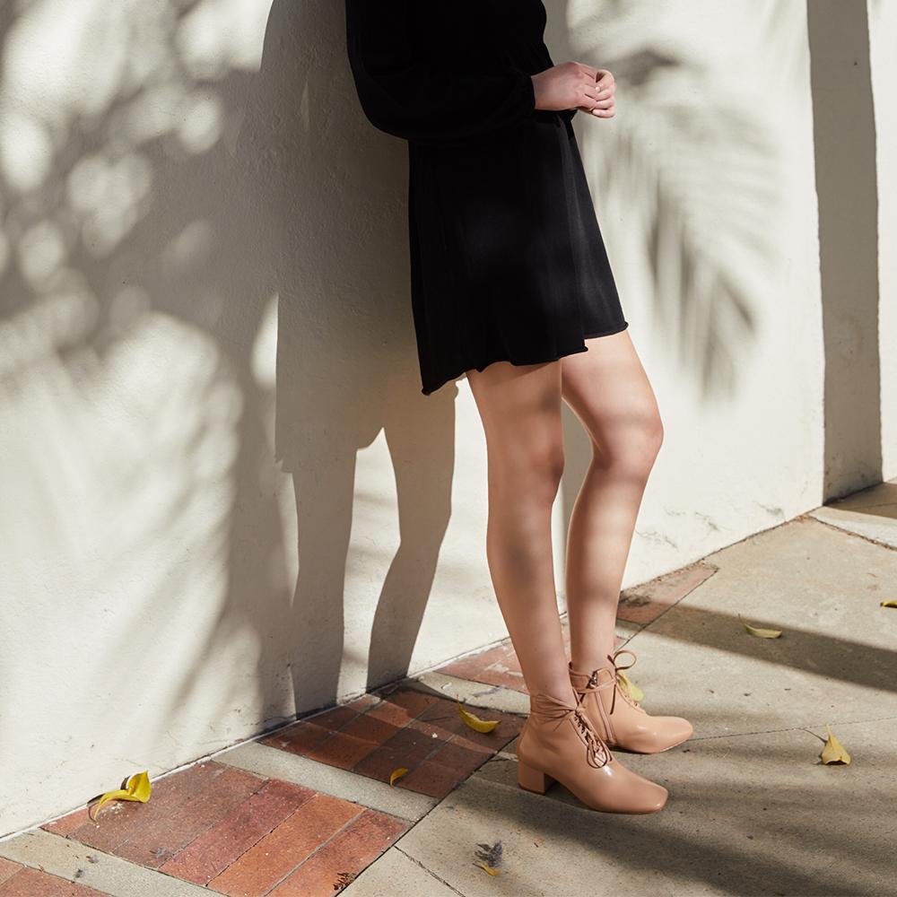 Daniella Shevel Cleo Nude Nappa Leather Boot with low Heel on model with Black Dress Look